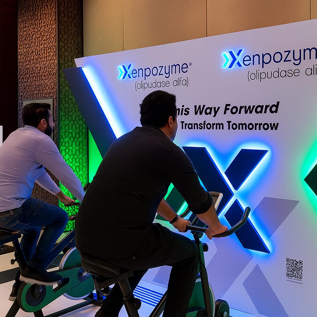 Guests enjoying Power Bike Challenge and Claw Machine game rentals at a Dubai corporate event, engaging in fun, branded, interactive experiences for team building and entertainment.